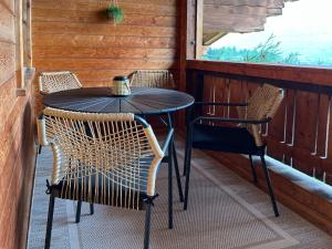 una mesa y sillas en el porche de una cabaña en Bergmanns Ferienapartment en Debant