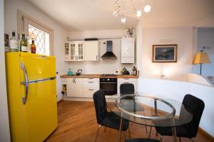 a kitchen with a glass table and a yellow refrigerator at Casa Vacanze Cecilia in Montinelle