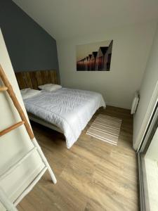 1 dormitorio pequeño con 1 cama y suelo de madera en La Caravelle, en Saint Gilles Croix de vie