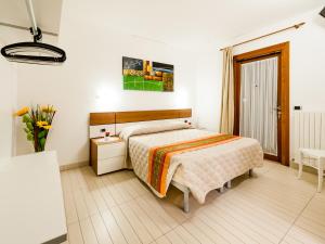 ビビオーネにあるCa' del Faro Bibioneのベッドルーム1室(ベッド1台、花瓶1本付)