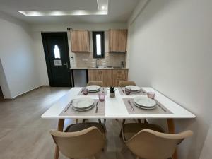 a white table and chairs in a room at Georges Estates Hotel in Stoupa