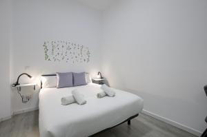 sypialnia z białym łóżkiem i 2 ręcznikami w obiekcie Atocha Station - Apartamento de 2 dormitorios w Madrycie
