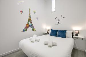 sypialnia z białym łóżkiem i wieżą Eiffel w obiekcie Atocha Station - Apartamento de 2 dormitorios w Madrycie