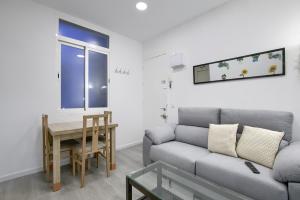 salon z kanapą i stołem w obiekcie Atocha Station - Apartamento de 2 dormitorios w Madrycie