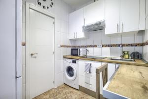 Biała kuchnia z pralką i zlewem w obiekcie Atocha Station - Apartamento de 2 dormitorios w Madrycie