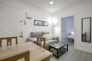 salon z kanapą i stołem w obiekcie Atocha Station - Apartamento de 2 dormitorios w Madrycie