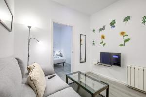salon z kanapą i telewizorem w obiekcie Atocha Station - Apartamento de 2 dormitorios w Madrycie