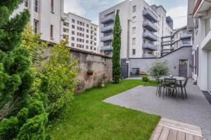 a small garden with a table and chairs and buildings at La Villa Sassolini in Lyon