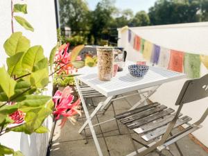 a white table and a chair on a balcony at L'Olympique: appartement cosy, vue canal grande terrasse et parking in Vaires-sur-Marne