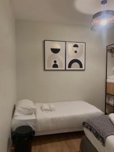 パリにある07 ベスト フラット オブ グランド ブルバードのベッドルーム1室(壁に3枚の写真が飾られたベッド1台付)
