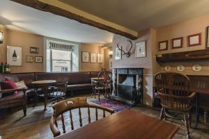 a bar with a fireplace and a table and chairs at The White Swan Inn in Pickering