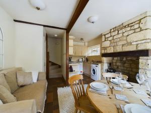 uma cozinha e sala de estar com uma mesa e um sofá em Romantic Cottage Cotswolds Parking Wi-Fi em Winchcombe