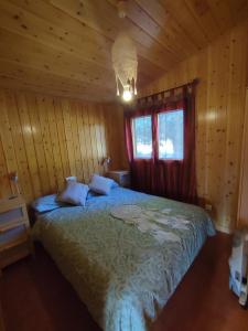 een slaapkamer met een bed in een houten hut bij Mi casita de madera in Segovia
