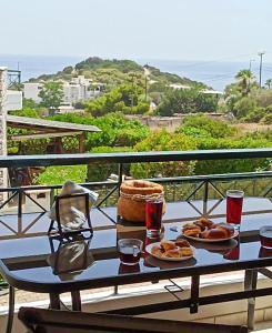 uma mesa com dois pratos de comida numa varanda em Melrose maisonette by the sea em Anavissos