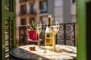 butelkę szampana i dwa kieliszki na stole w obiekcie 2 bedrooms Apt, 10 mins to SAGRADA FAMILIA w Barcelonie