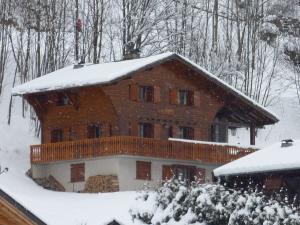 a large wooden house with snow on the roof at Two Bedroom Apartement Belle Vue in La Chapelle-dʼAbondance