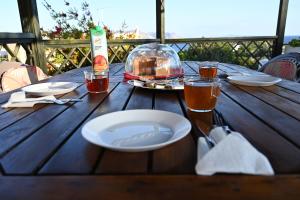 una mesa de madera con un plato de comida y bebidas. en Melrose maisonette by the sea, en Anavyssos
