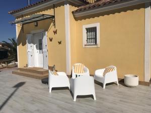 un grupo de sillas sentadas frente a una casa en Villa Estrella with private pool, en Mazarrón