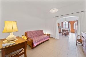 uma sala de estar com um sofá e uma mesa em La casa Rosa em SantʼAnna Arresi