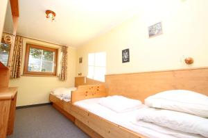 1 Schlafzimmer mit 2 Betten und weißer Bettwäsche in der Unterkunft Ferienwohnung Königsleiten 210 - Top 1 in Königsleiten