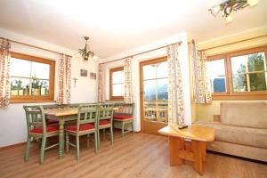 een woonkamer met een tafel en stoelen en een bank bij Ferienwohnung Königsleiten 210 - Top 1 in Königsleiten