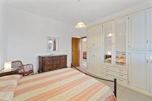 um quarto com uma cama grande e uma cómoda em La casa Rosa em SantʼAnna Arresi