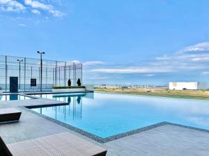 a swimming pool with blue water in a building at Amber Cove l Luxury Seaview 2BR l 6-8pax l GamesRoom l City Centre l Jonker St by Jay Stay in Melaka