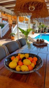 アラウリン・エル・グランデにあるCasa Olivaのプールサイドの木製テーブルに果物を盛り付けて