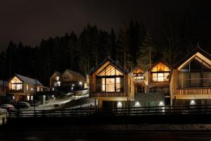 a row of wooden houses at night with lights at TRI VODY Demänovská Dolina in Liptovský Mikuláš