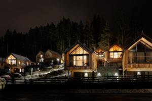 eine Reihe von Holzhäusern in der Nacht mit Lichtern in der Unterkunft Tri Vody Demänovská Dolina in Liptovský Mikuláš