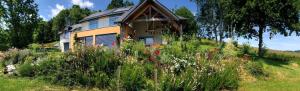 a house on a hill with a field of flowers at Poulou Pyrénées in Gelos