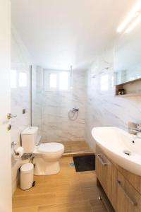 bagno bianco con servizi igienici e lavandino di Volos Horizon Oasis Apartment #1 a Volos