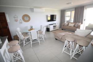 sala de estar con sofá, mesa y sillas en Laguna La Crete 13, en Uvongo Beach