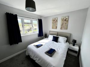 a bedroom with a bed with two pillows on it at House near Swansea & Brecons! in Aberdulais