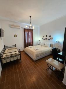 a bedroom with a large bed and a chair at Alice Maisonette & Studios in Adamantas