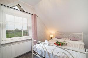 a white bed in a room with a window at Villa Mare in Łeba