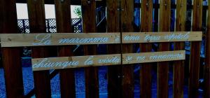 un banco de madera con dos letreros en una valla en B&B Maremma's dream, en Catabbio