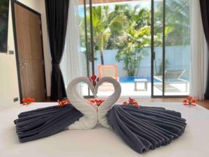 twee zwanen in de vorm van harten zittend op een bed bij Landmark Villa 2 in Ban Saiyuan (1)