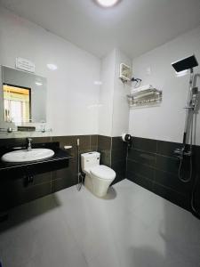 Thanh Bình Hotel في Ðoan Xá: حمام مع مرحاض ومغسلة ومرآة