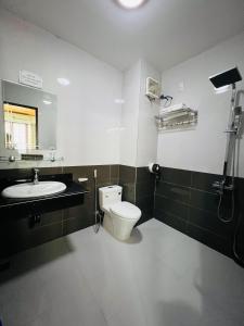 a bathroom with a toilet and a sink and a mirror at Thanh Bình Hotel in Ðoan Xá