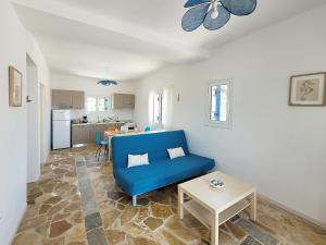 a living room with a blue couch and a table at SempreViva Sea Houses in Diakofti