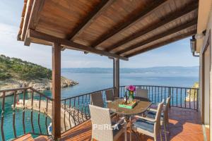 einen Blick vom Balkon eines Hauses mit einem Tisch und Stühlen in der Unterkunft Villa BELLA MARE with stunning Sea Views in Vrbnik