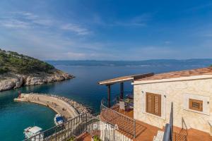 ein Haus mit einem Balkon und Blick auf einen Wasserkörper in der Unterkunft Villa BELLA MARE with stunning Sea Views in Vrbnik