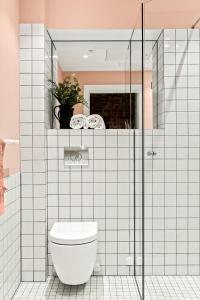 a bathroom with a toilet and a glass shower at BJØRVIKA APARTMENTS - Solli in Oslo