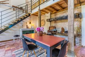 a dining room with a wooden table and chairs at Domaine les Maisons des Houssats in Trensacq