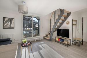 a living room with a staircase and a tv at Appartement vue mer et les pieds dans l'eau! in Saint-Sébastien