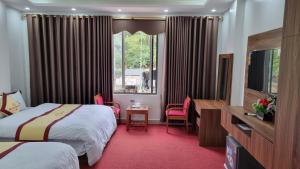 Habitación de hotel con 2 camas y ventana en Friend Hotel Hà Giang en Ha Giang
