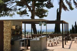 eine Terrasse mit Tischen und Stühlen und einem Pavillon in der Unterkunft Masseria del Carboj in Menfi