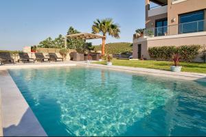 una piscina frente a una casa en Luxury Villa Argi infinity private pool, en Kissamos