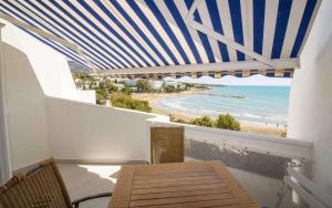a balcony with a table and a view of the beach at Atico loft en primera linea EURHOSTAL Albert Villas in Alcossebre